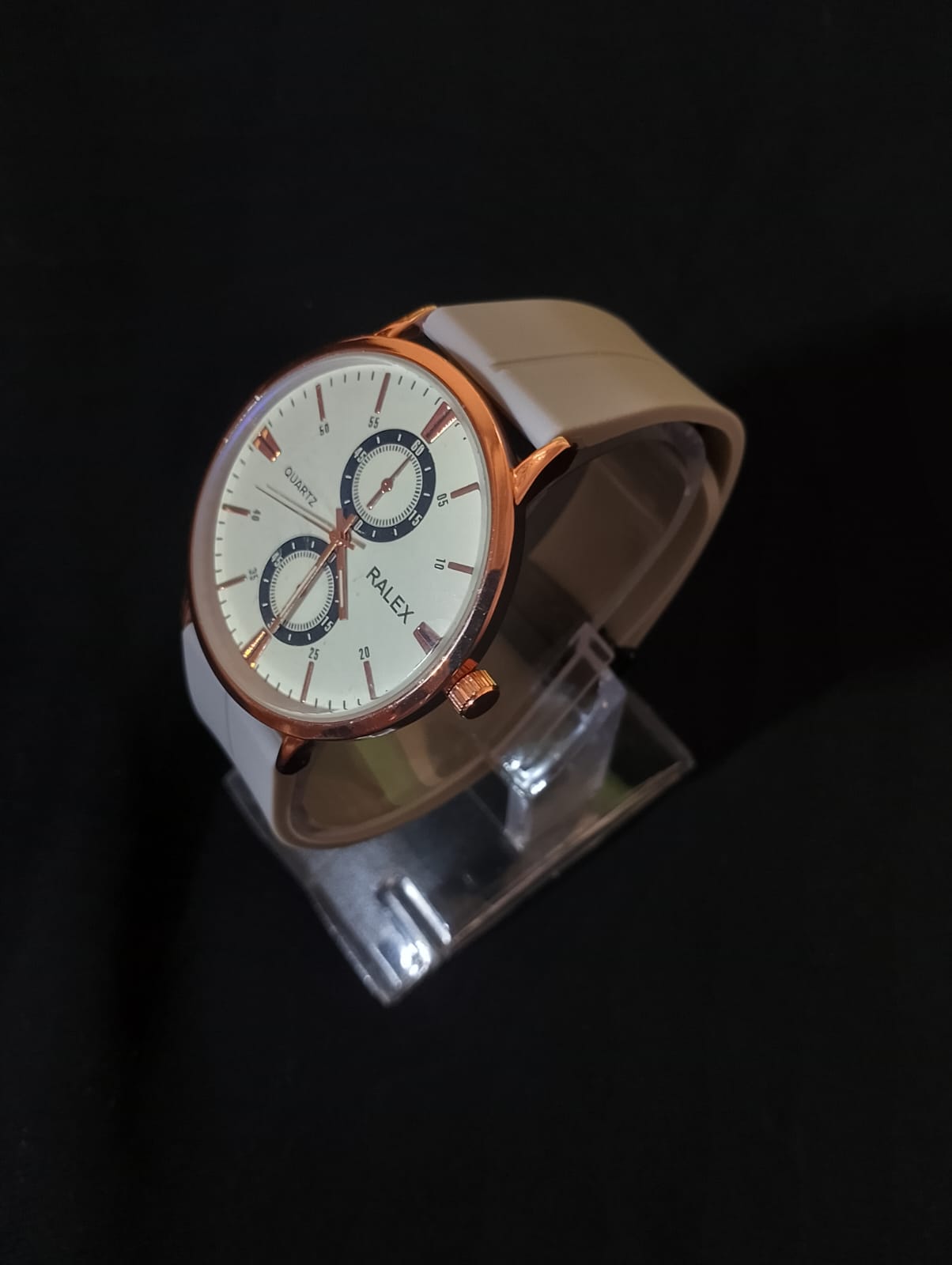 Stylish timepiece with a rose gold case, a white dial, and a grey strap.