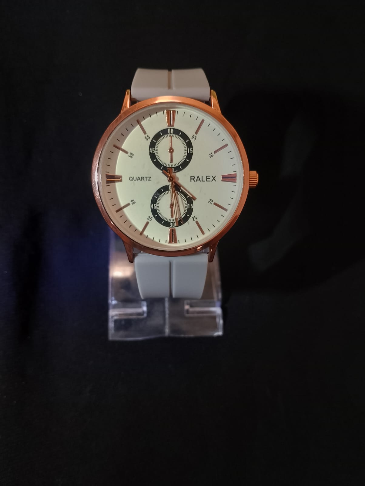 Stylish timepiece with a rose gold case, a white dial, and a grey strap.