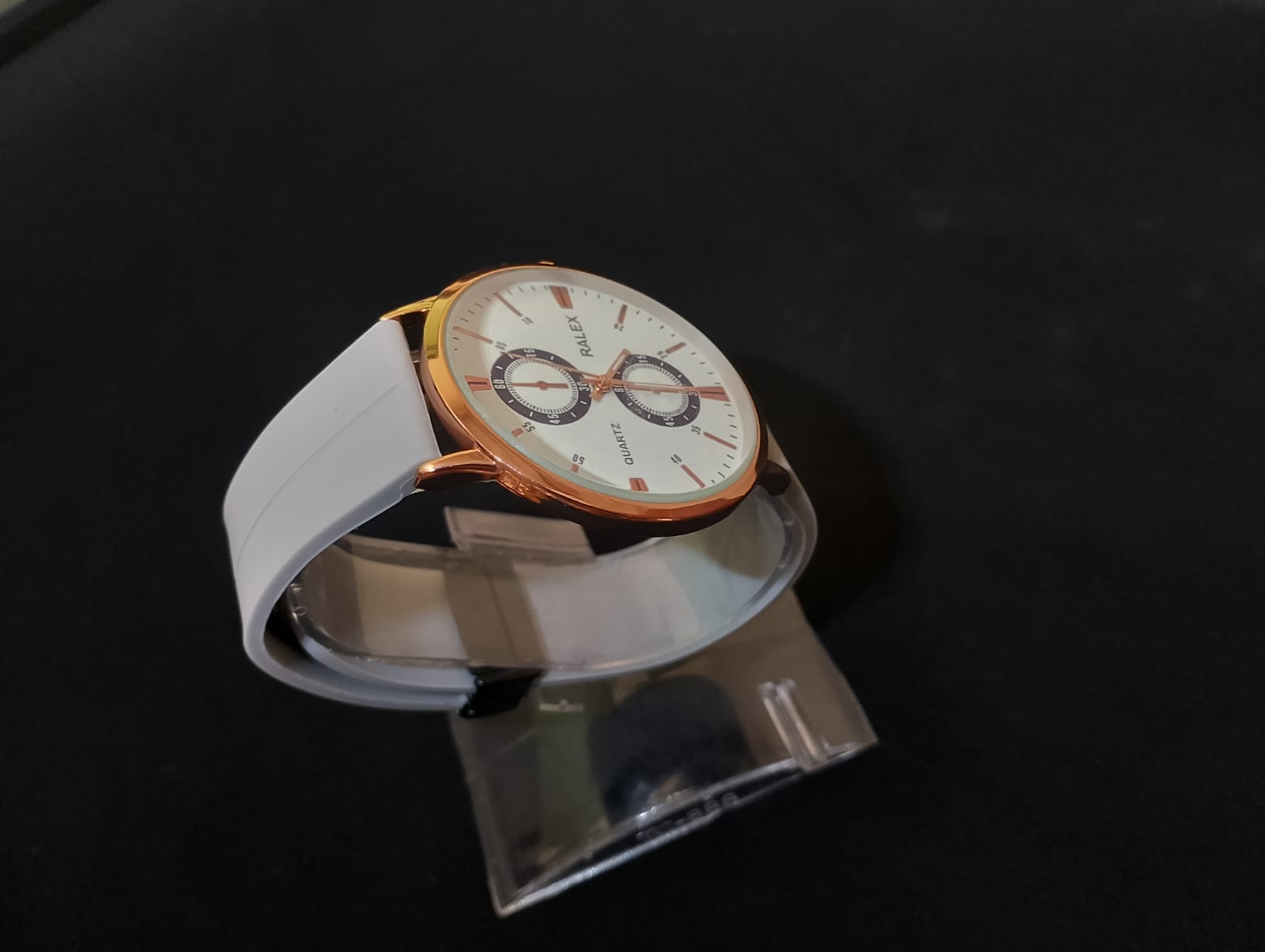 Stylish timepiece with a rose gold case, a white dial, and a grey strap.