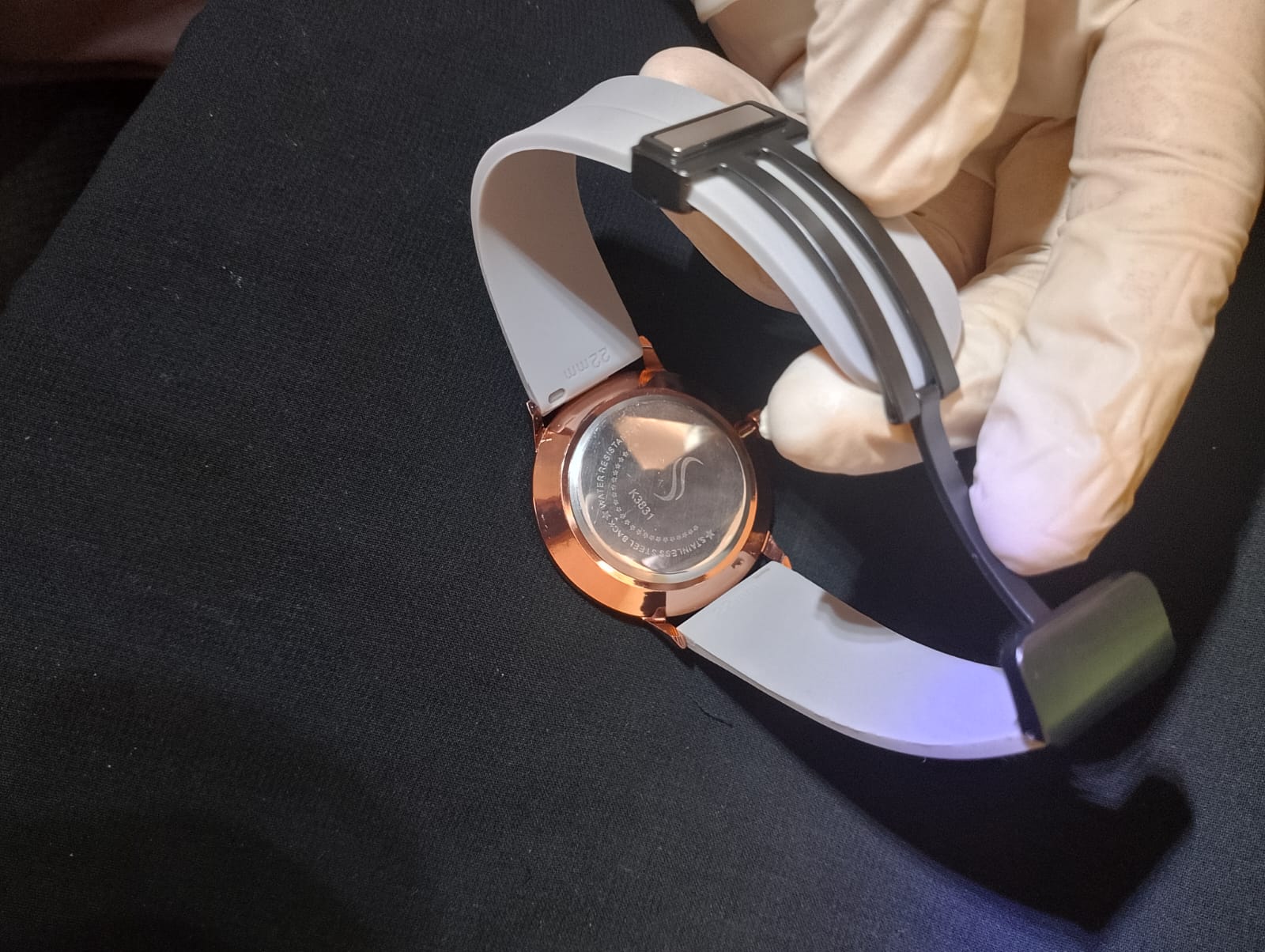 Stylish timepiece with a rose gold case, a white dial, and a grey strap.