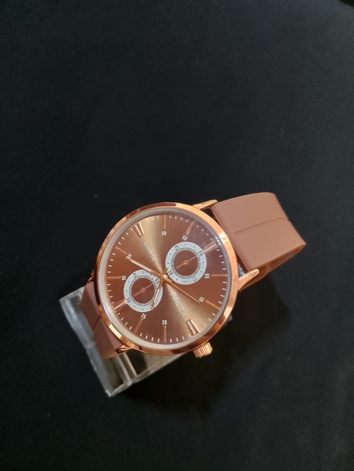 Stylish timepiece with a rose gold case, a white dial, and brown strap.