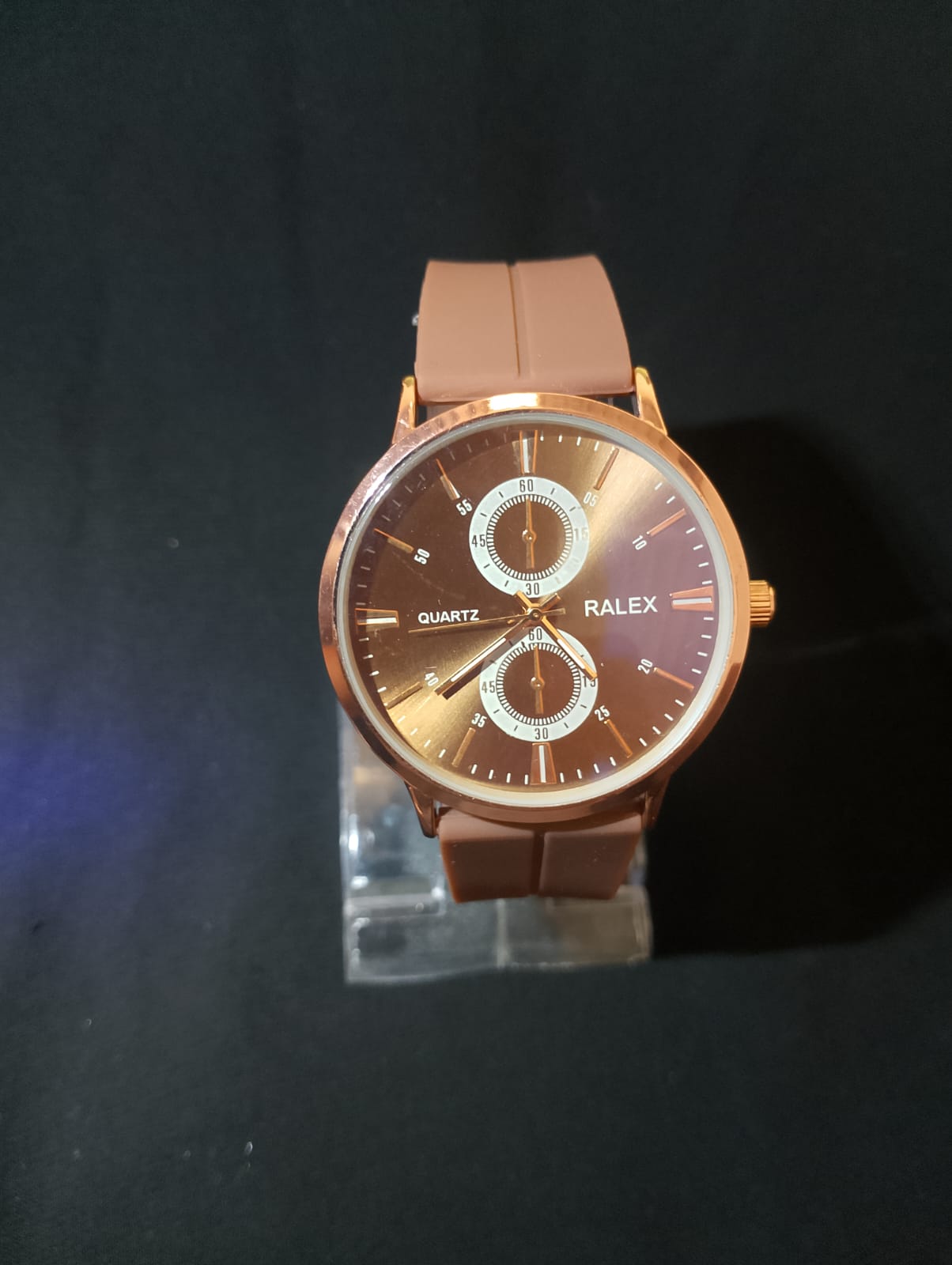 Stylish timepiece with a rose gold case, a white dial, and brown strap.