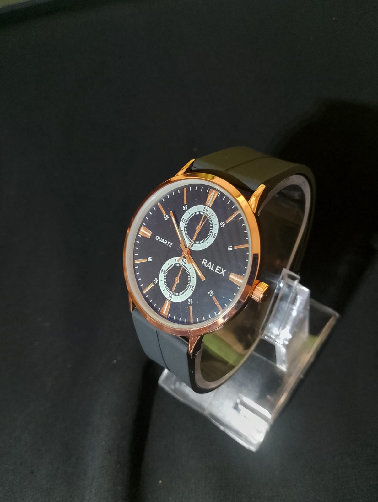 Stylish timepiece with a rose gold case, a black dial, and a black strap.