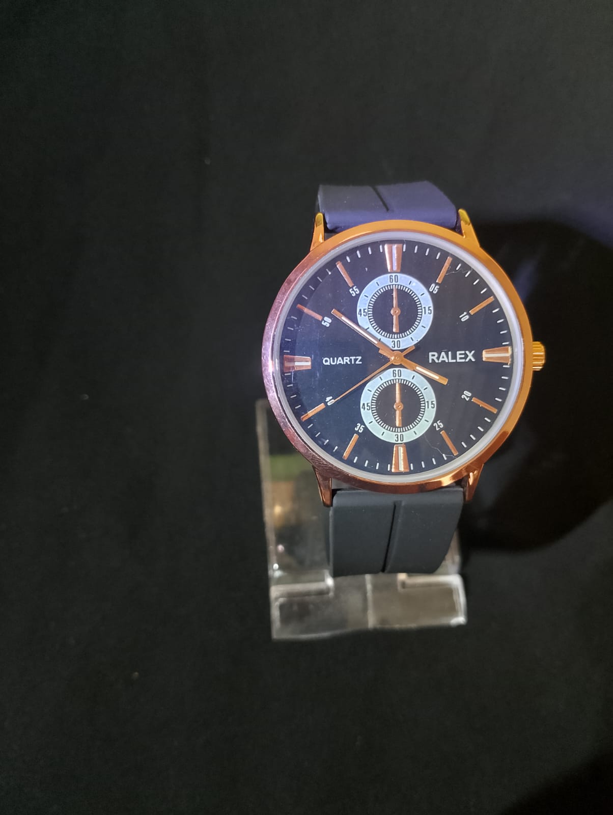 Stylish timepiece with a rose gold case, a black dial, and a black strap.