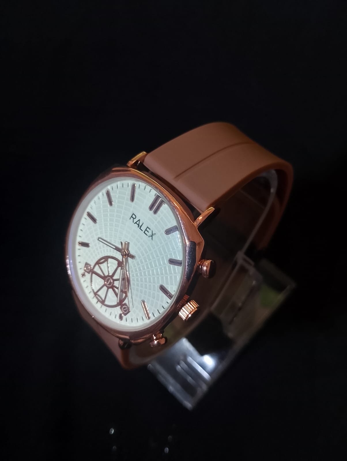 Ralex brand wrist watch with a brown silicone strap and a rose gold-toned case.