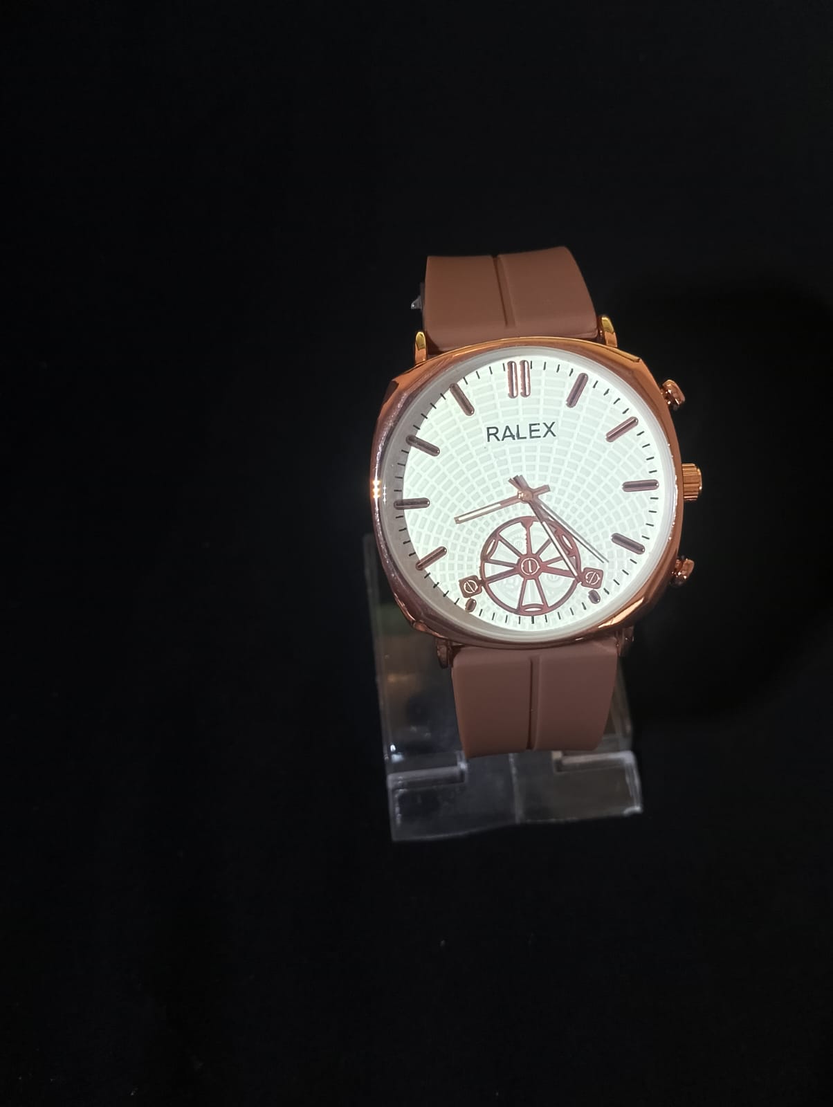 Ralex brand wrist watch with a brown silicone strap and a rose gold-toned case.
