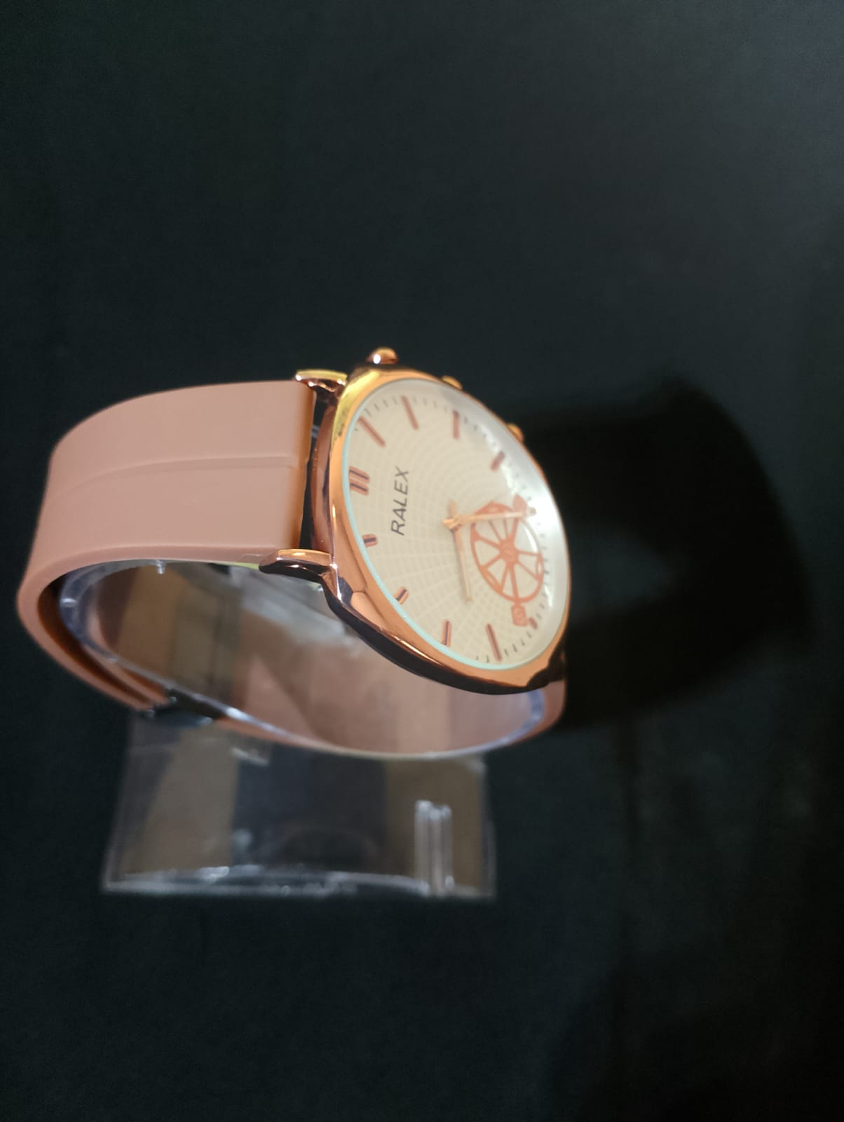 Ralex brand wrist watch with a brown silicone strap and a rose gold-toned case.