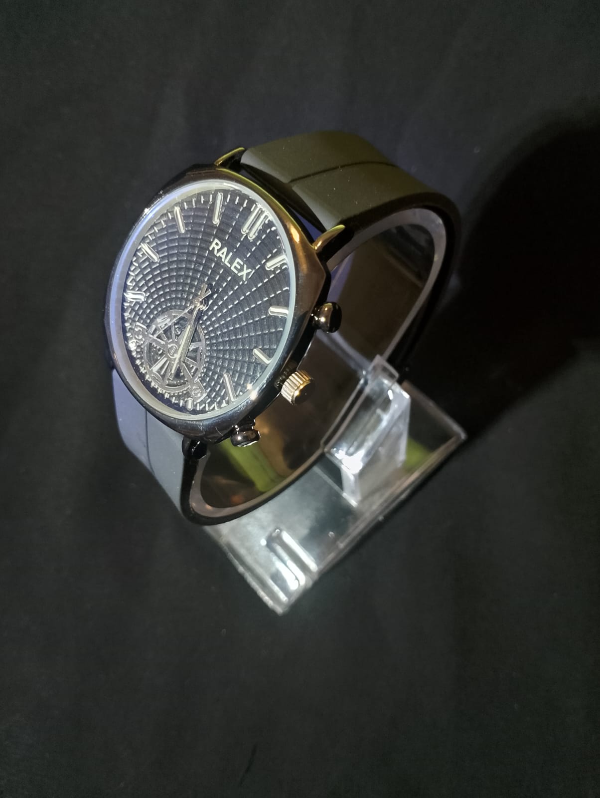 Ralex brand wrist watch with a brown silicone strap and a black -toned case.