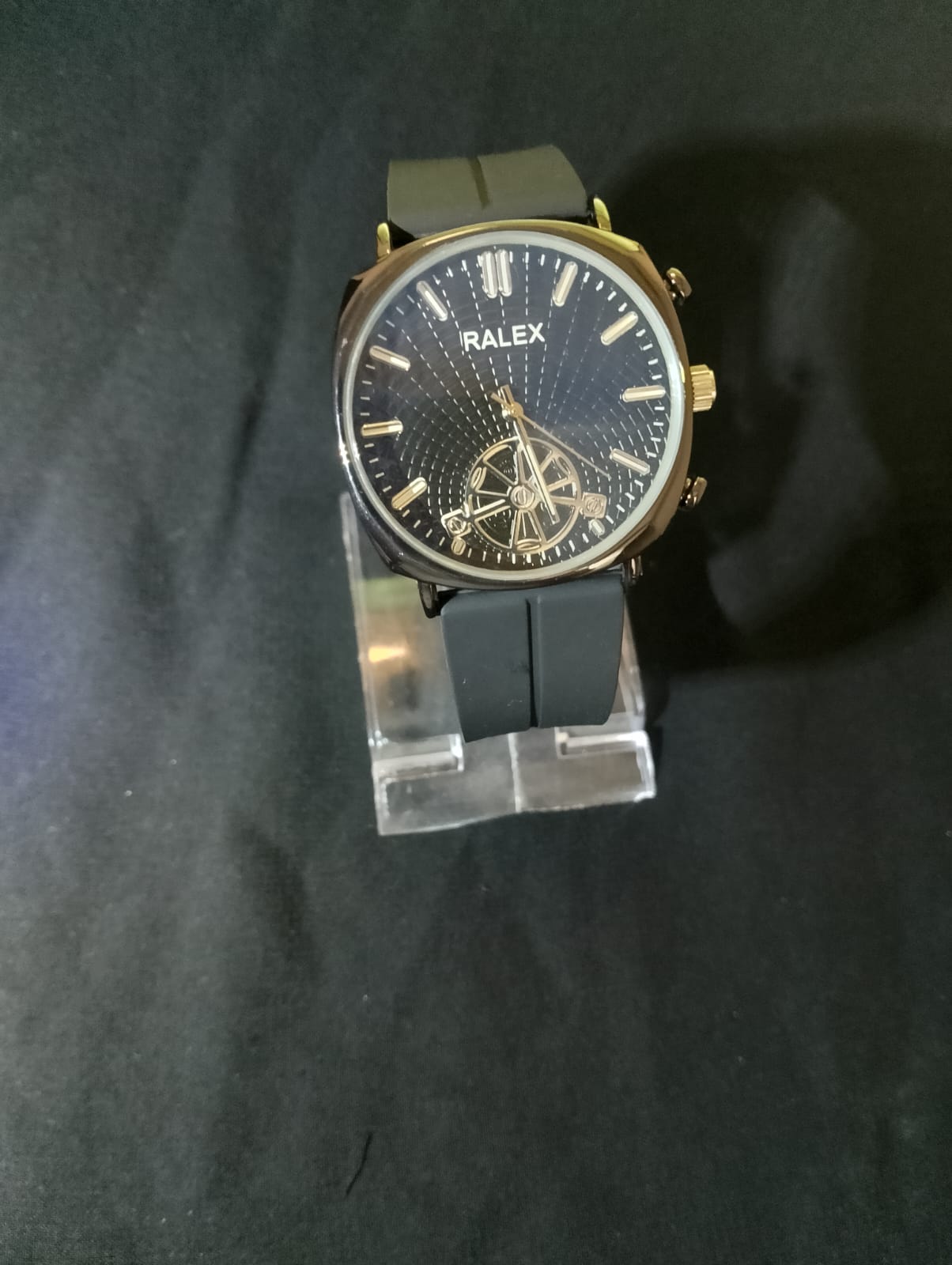 Ralex brand wrist watch with a brown silicone strap and a black -toned case.