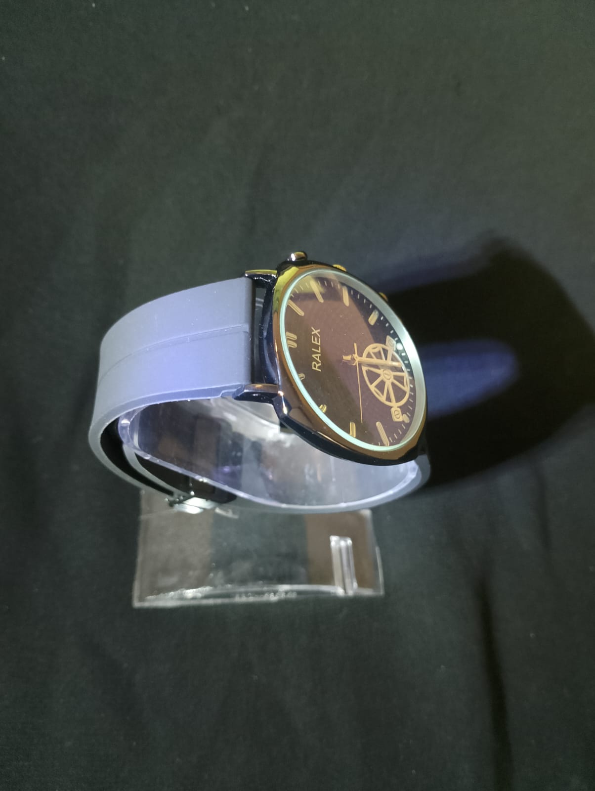 Ralex brand wrist watch with a brown silicone strap and a black -toned case.